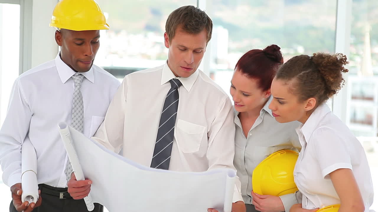 un grupo de arquitectos de construcción mirando los planos