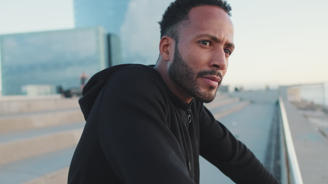 Man in hoodie outdoors near buildings