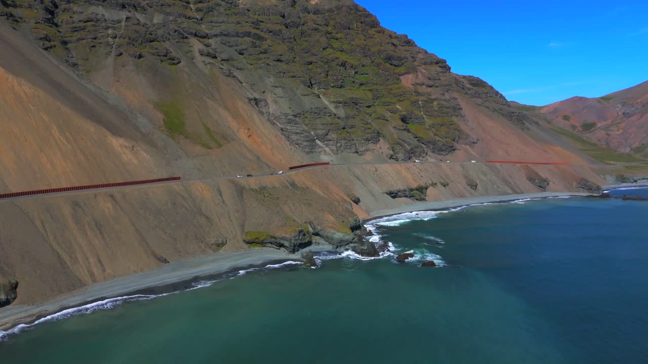 Journey over Iceland’s majestic terrain as the drone glides above the shimmering ocean, revealing the captivating interplay of land and sea in this breathtaking natural wonder.