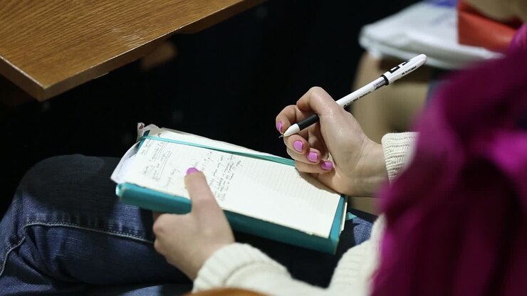 Female Hand Over Paper Notes. Female hand over paper making notes at seminar