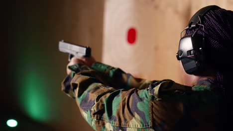 retrato de una mujer en el campo de tiro preparándose para una misión, disparando una pistola