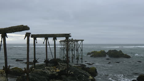 ruins of the historic, 120-year-old pier in llico, vichuquen, chile, wide shot