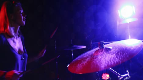batería femenina tocando en un conjunto de tambores 4k