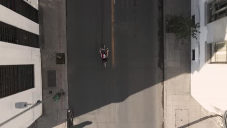 bird eye of girl on bike in santiago de chile, uhd 4k aerial