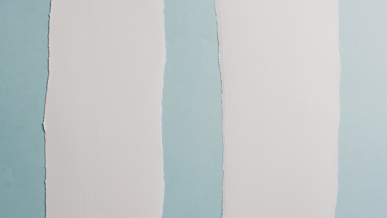 video de primer plano de pedazos rasgados de papel blanco sobre fondo azul