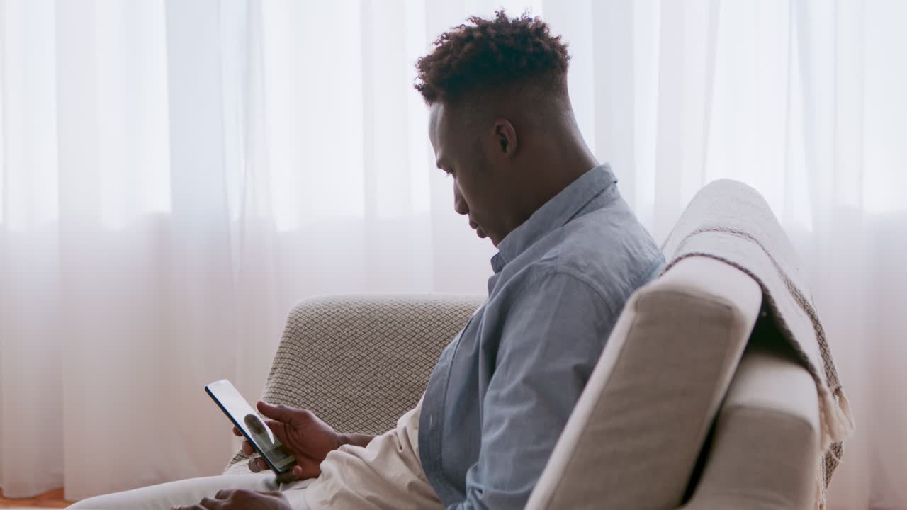 Man using smartphone on couch