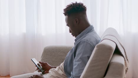 hombre usando teléfono inteligente en el sofá