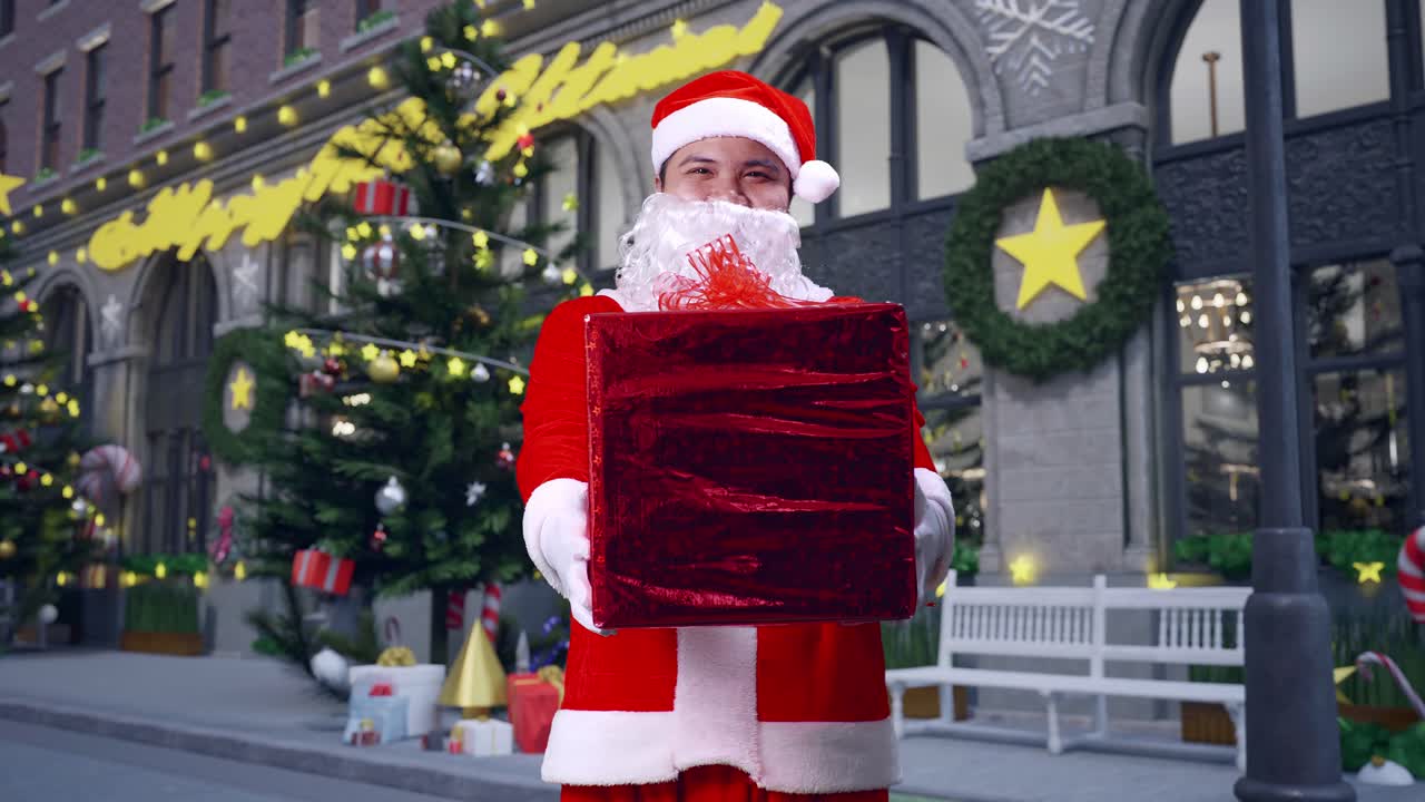 아시아 산타클로스가 크리스마스 밤에 서서 카메라에 선물을 주는 모습