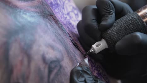 artista del tatuaje tatuando una gran pieza de la espalda