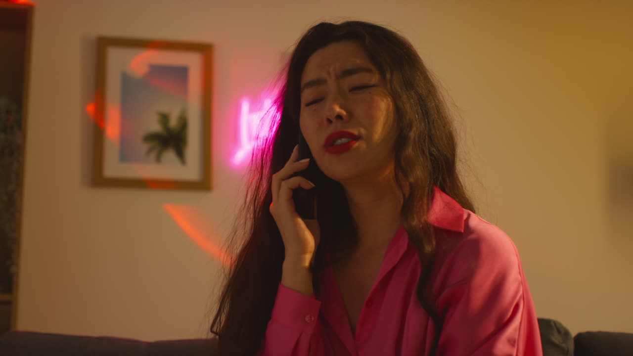 집 파티에서 알코올을 마신 후 소파에서 깨어난 여성은 숙취로 고통 받고 휴대 전화로 이야기합니다.