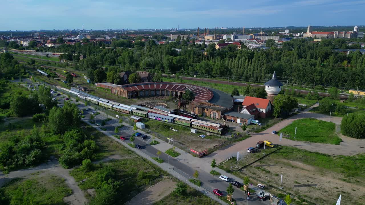 historic steam locomotive shed and trains depot with surrounding urban city Berlin Germany landscape, industrial heritage. Smooth aerial view flight panorama orbit drone
