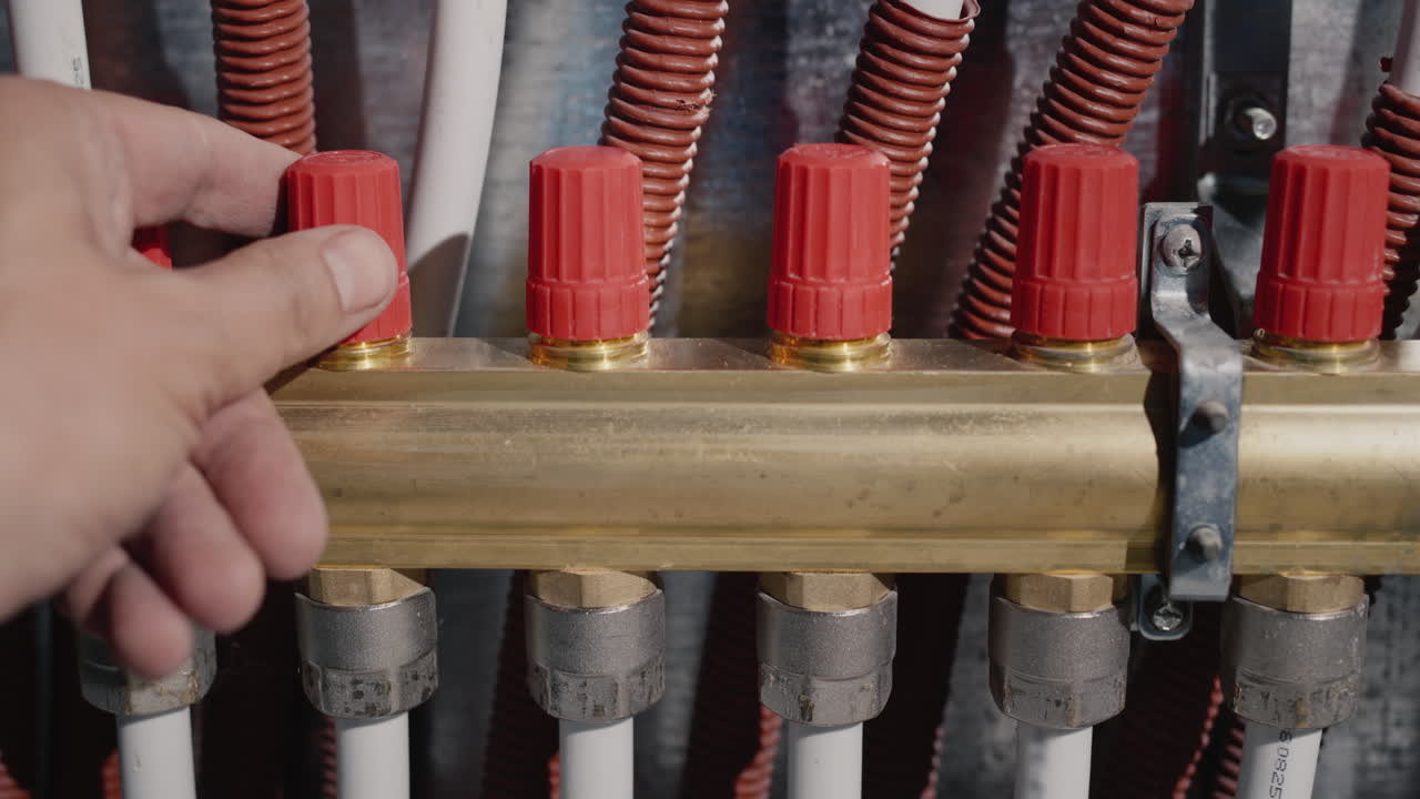 el dueño de la casa ajusta el sistema de calefacción. regula el suministro de agua caliente a radiadores y calefacción por suelo radiante