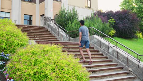 young asian man climbs up the stone stairs, applying for university