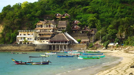 Colourful-boats-anchored-by-paradise-tropical-beach-at-Gerupuk-bay,-Lombok,-Indonesia