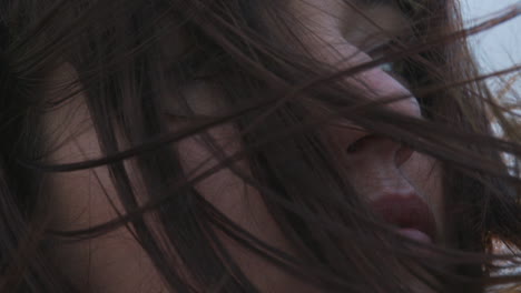 close-up of a young female in her 20s standing outside in the wind