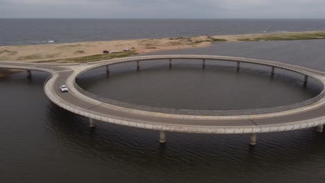 Car-crosses-Laguna-Garzón-Circular-Bridge,-aerial-view