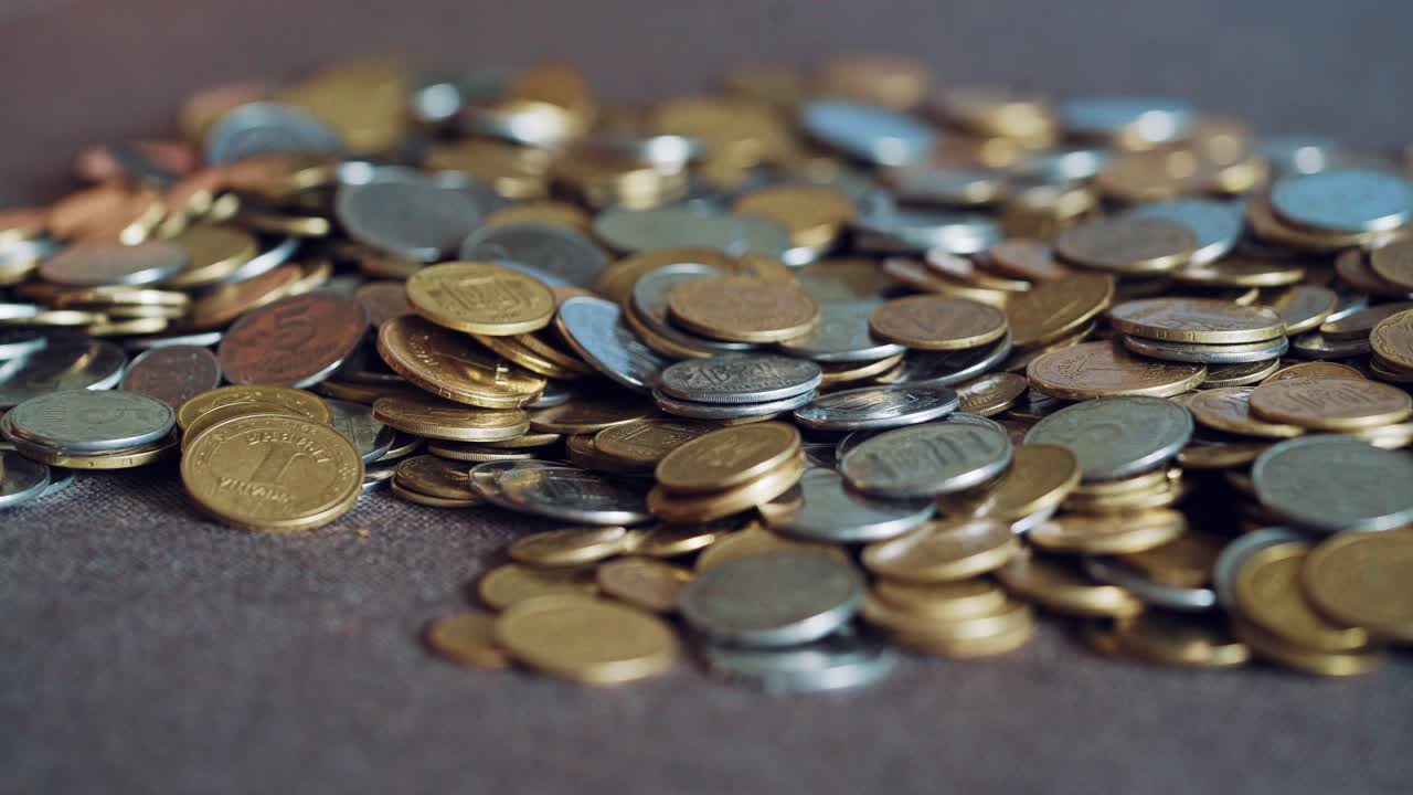 Child plays with coins. Large pile of money coins