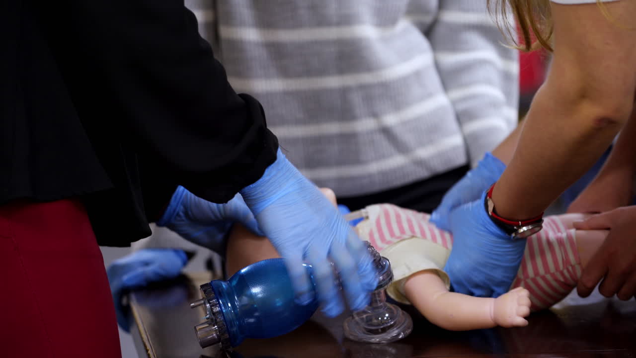 Practical medical course on a mannequin. Practitioners doing cardiopulmonary resuscitation on a baby doll. Chest compression and breathing. CPR medical training.