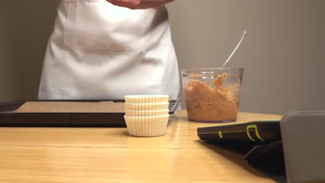 Mujer-Con-Delantal-Haciendo-Curso-De-Cocina-A-Través-De-La-Tableta