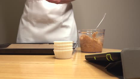 mujer con delantal haciendo curso de cocina a través de la tableta.