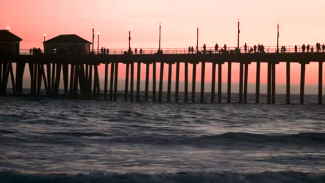 Ms-Von-Huntington-Beach-Pier-In-Der-Abenddämmerung-Mit-Menschen,-Die-Am-Pier-Entlang-Gehen