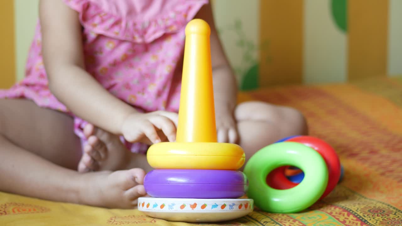 Bambino che gioca con giocattoli per neonati sul letto, concetto di sviluppo infantile
