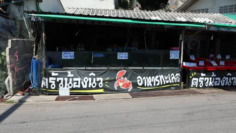 white car driving past a shop with signage