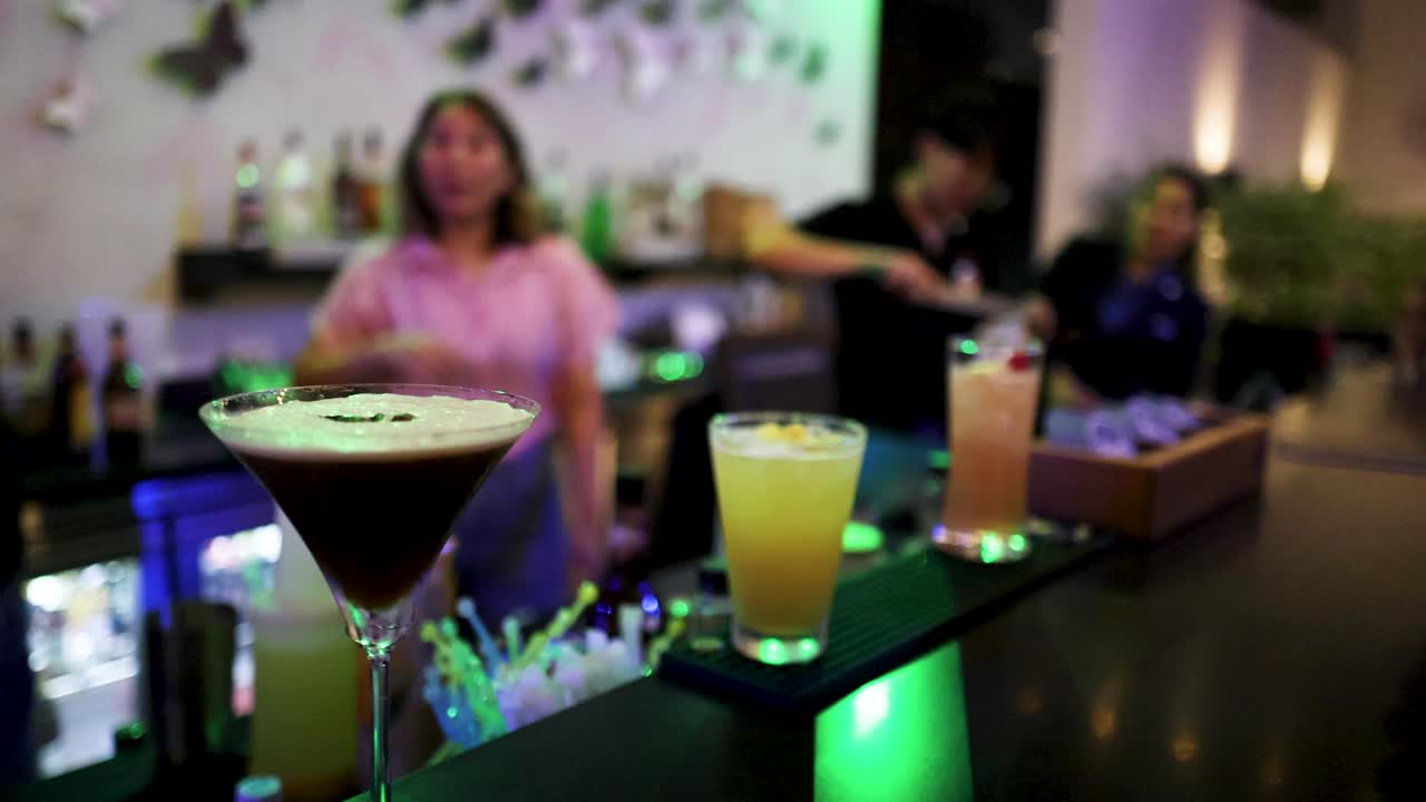 A lively bar setting with colorful cocktails and dynamic lighting. Bartenders prepare drinks, creating a vibrant and energetic atmosphere