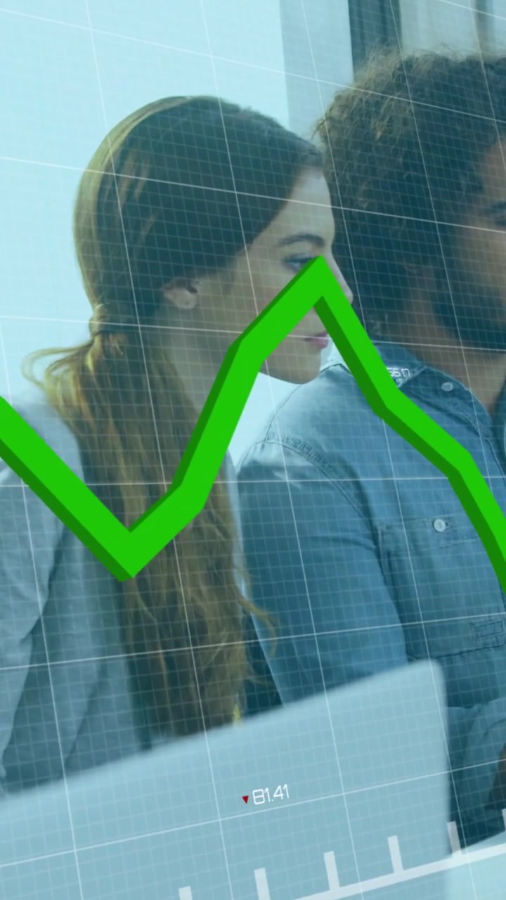 Video verticale: Analista che si china per monitorare i prezzi, grafico finanziario verde che scorre sullo schermo di un laptop