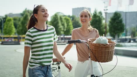 handheld video of two women walking with a white bike