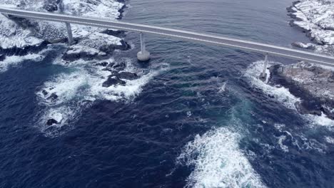 aerial view of a djupfjordbrua bridge that spans across a body of dark, turbulent water of ocean