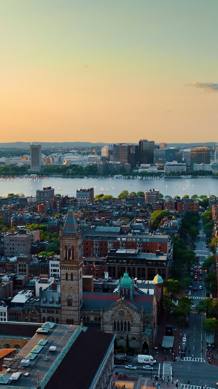 Stunning low-rise city architecture on the river bank. Scenery of Boston at sun down from top.. Vertical video