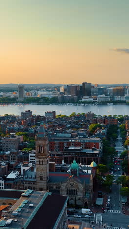 Stunning low-rise city architecture on the river bank. Scenery of Boston at sun down from top.. Vertical video