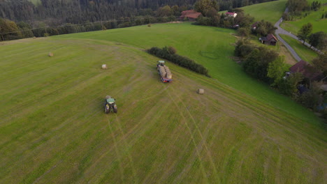 aerial view of agricultural machinery harvesting crops in hilly landscape