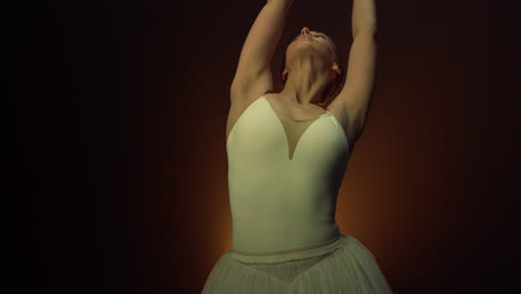 elegant woman dancing ballet indoors. flexible ballerina moving hands in air.