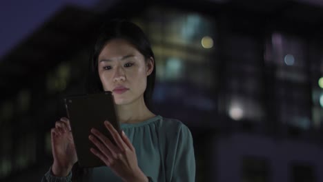 video of thoughtful asian businesswoman using tablet at night in office