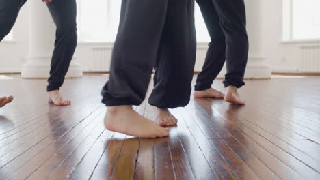 primer plano de las piernas de tres bailarines contemporáneos entrenando movimientos de baile en el estudio 1