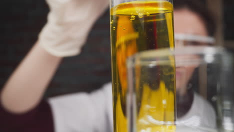 Lab-assistant-puts-test-tube-with-red-liquid-sample-on-rack