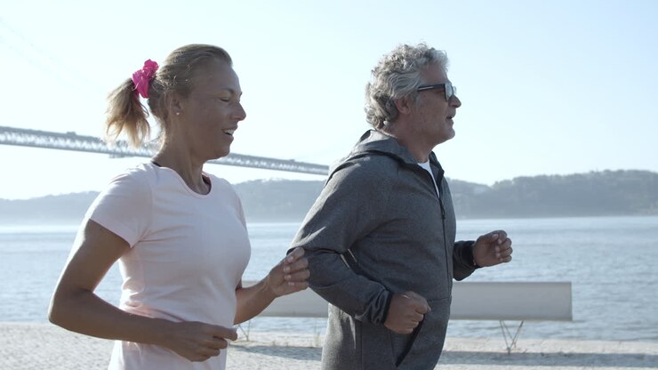 Vrolijke hardlopers die samen trainen en glimlachen tijdens het joggen.