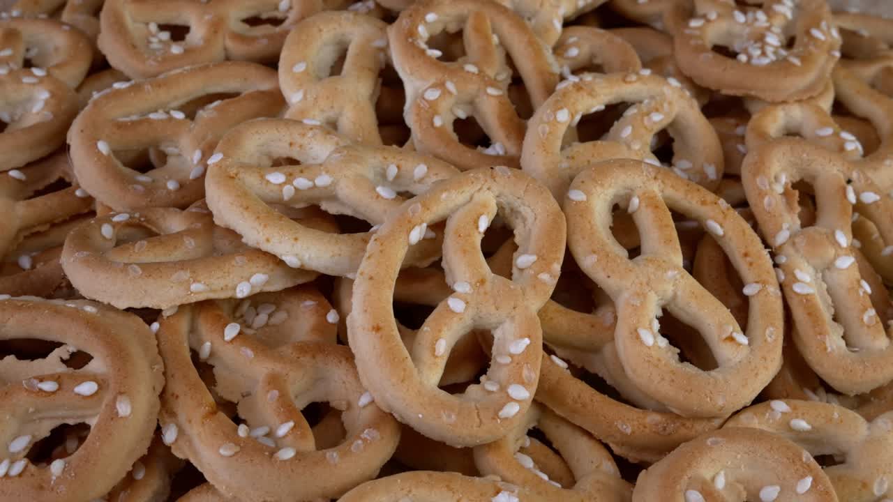 Kasa pretzeleitä seesaminsiemenillä ripoteltuna pyörii pyöritysalustalla. Epäterveellistä mutta herkullista pikaruokaa