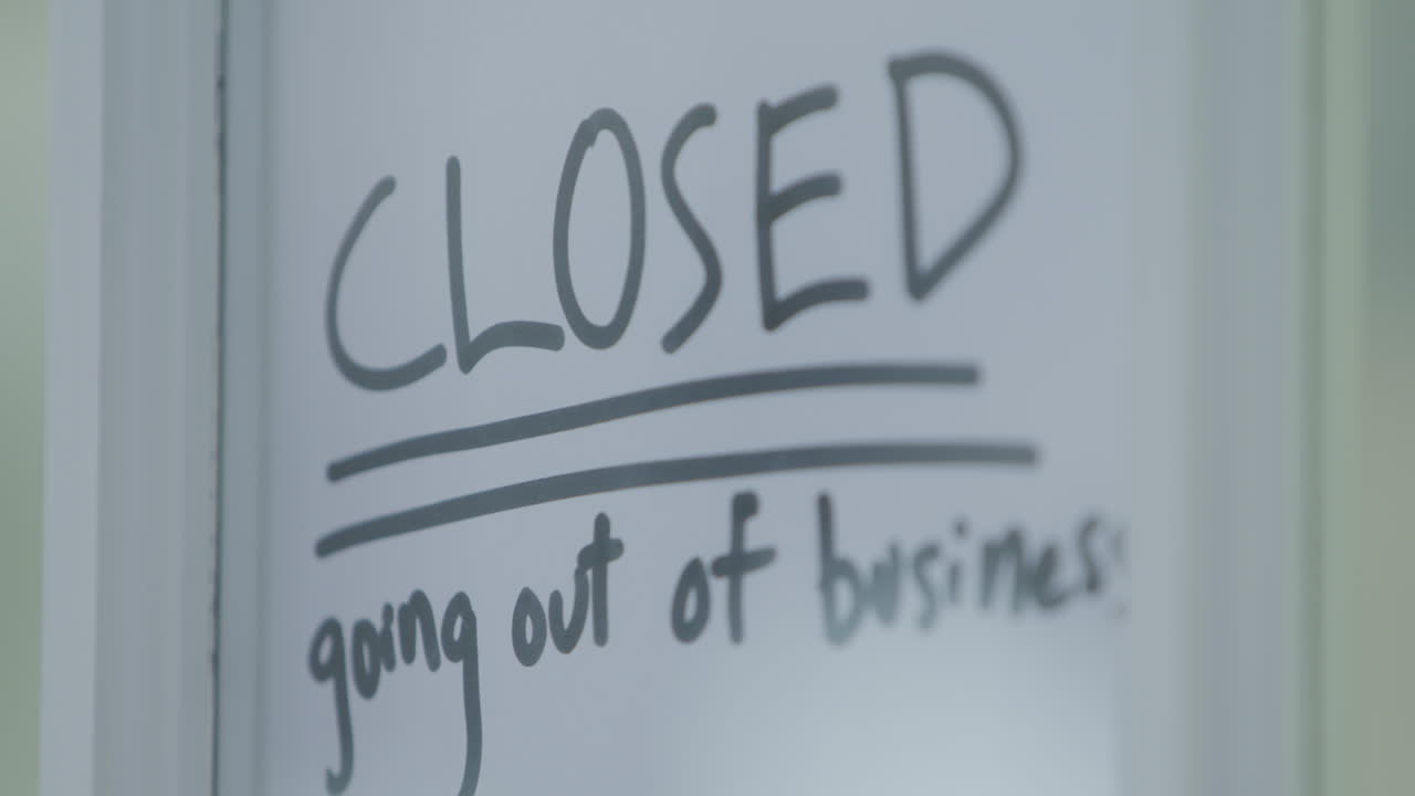 A door on a store closing with a sign on it