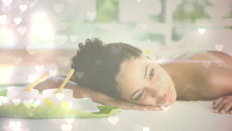 relaxing woman at spa with candles and flowers, hearts animation over scene