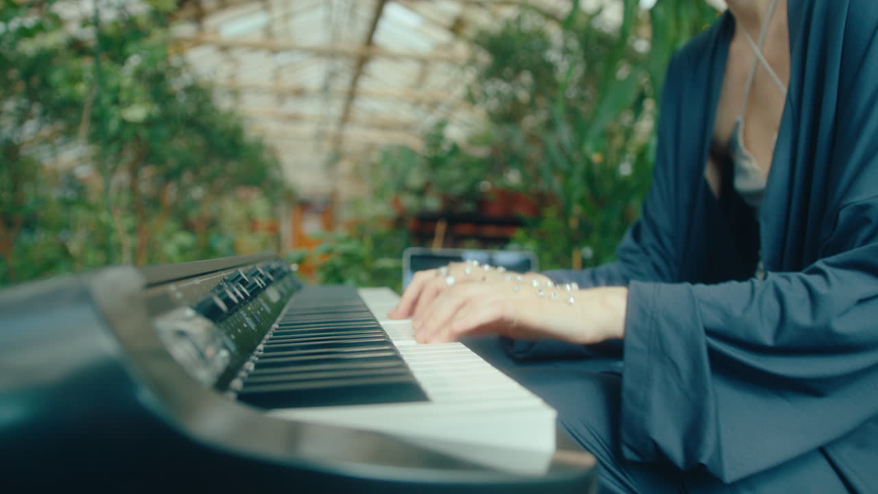 Female Pianist with Gem-Adorned Hands Playing Keyboard in Indoor Garden