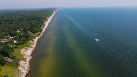 Boat-sailing-parallels-to-the-Coast-of-Lake-Michigan-in-the-heat-of-Summer-Near-Muskegon,-MI