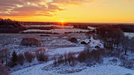 incredible sunset over a winter snow landscape with rural farmhouse