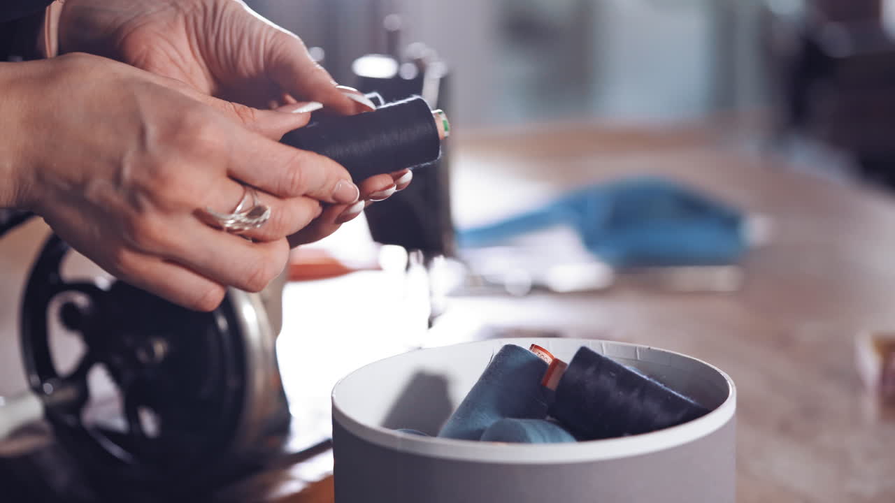 Box with color sewing threads. Close up of woman hands opening tailor box with threads