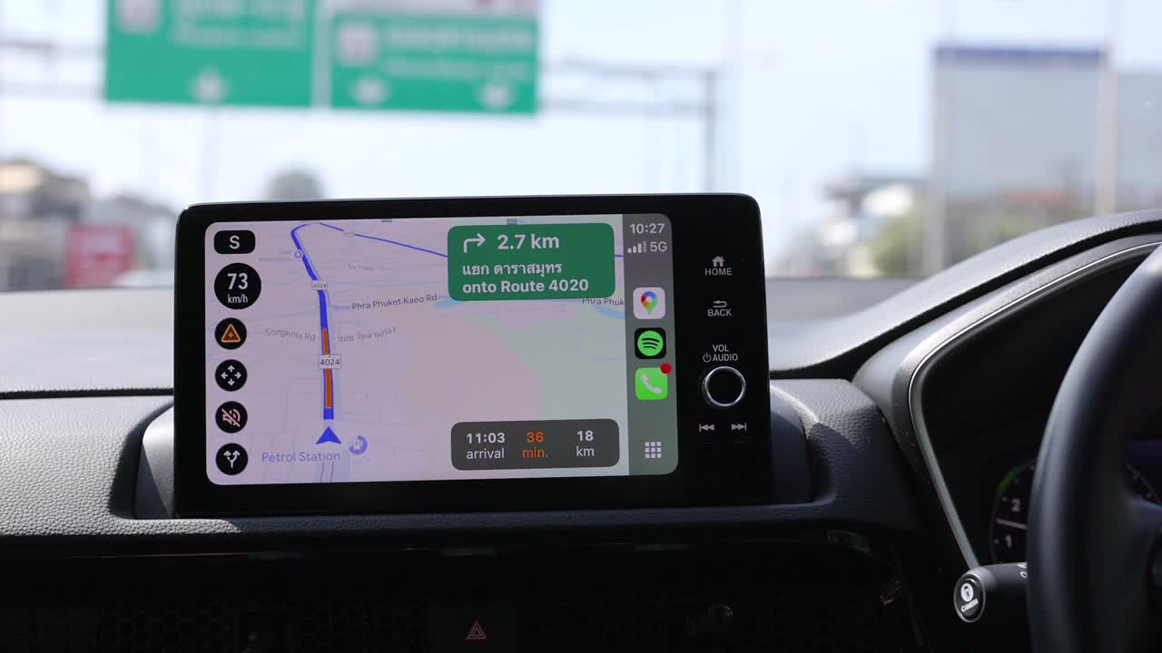 In-car navigation system guides through Phuket roads, displaying route and distance. Bright daylight, clear screen, and smooth driving