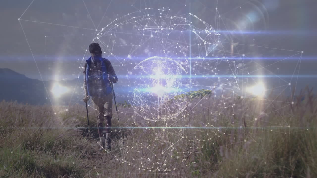 Hiker walking along mountain trail at dawn, showcasing glowing digital network sphere technology
