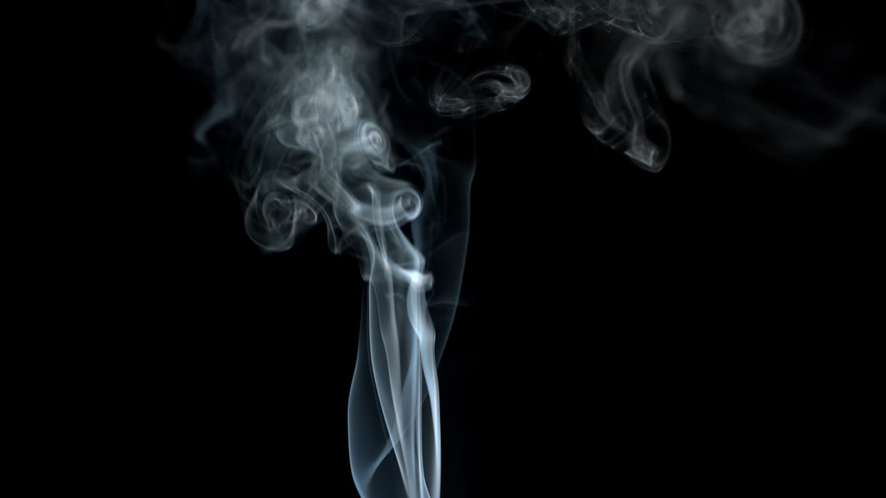 si alza fumo grigio su sfondo nero. il fumo si dissipa.