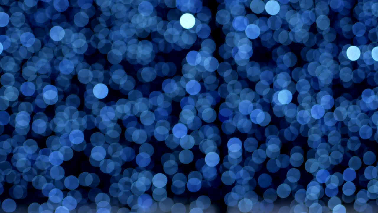 밤의 추상적인 파란색 배경은 멋진 보케로 분해되어 있습니다. 흐릿한 크리스마스 조명 보케.
